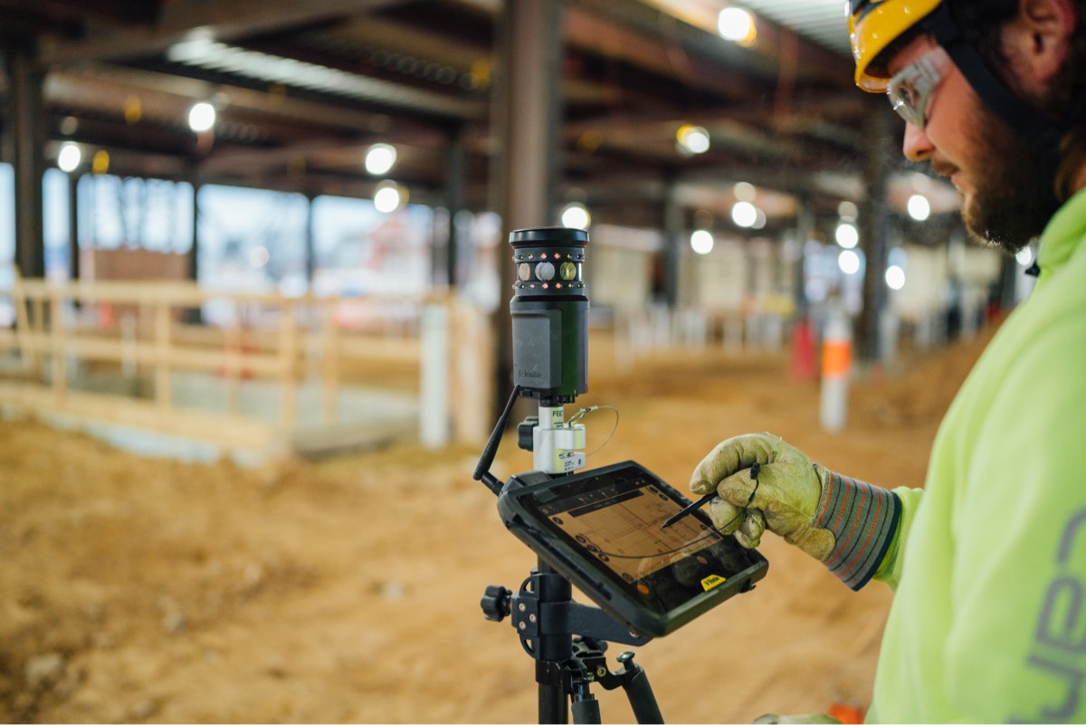 engineer using survey equipment on a construction site